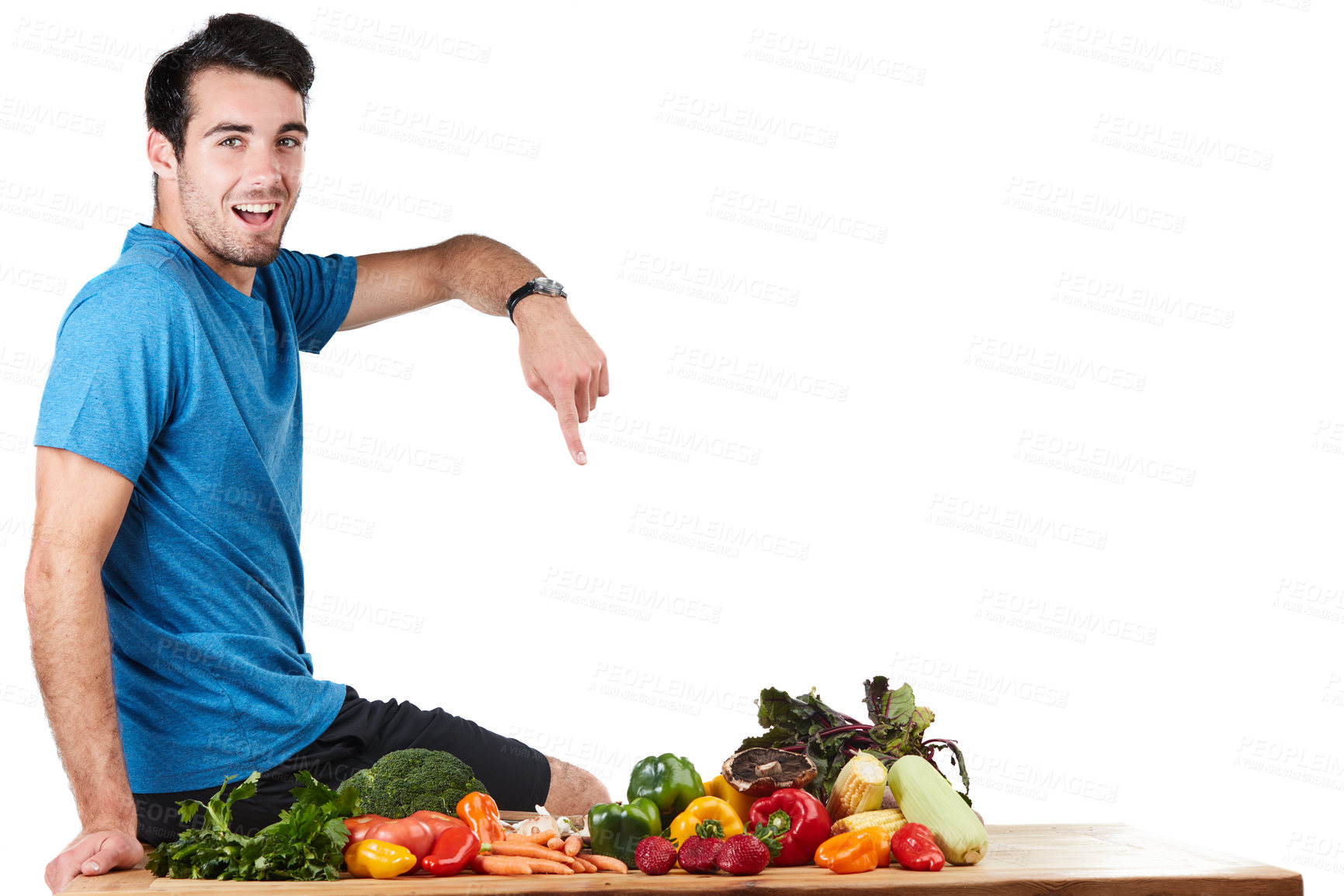 Buy stock photo Studio portrait of a handsome young man posing with a variety of fresh vegetables against a white background