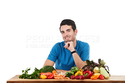 Buy stock photo Studio portrait of a handsome young man posing with a variety of fresh vegetables against a white background