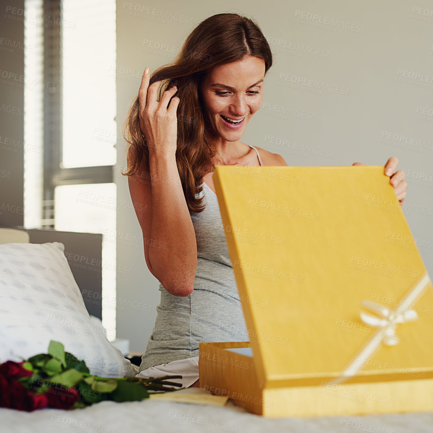 Buy stock photo Woman, bed and open box with roses, present and happy for surprise on birthday, valentines day and event. Girl, cardboard package and gift, smile and bedroom with thinking in home for celebration