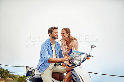 Buy stock photo Shot of an affectionate couple looking at a map while out on their motorcycle