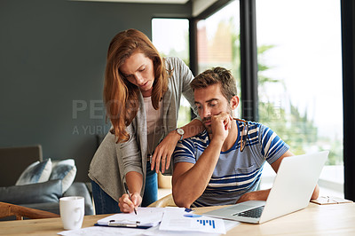Buy stock photo Cropped shot of a young couple working on their household budget and paying bills online