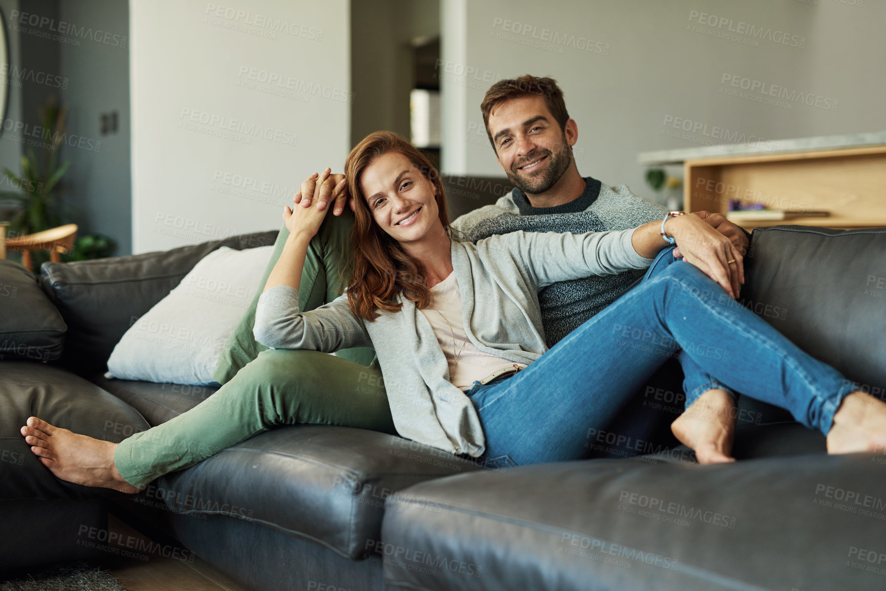 Buy stock photo Couple, home and happy on sofa in living room for bonding, care and support as lovers. People, portrait and smile with confidence for relationship on couch in love on break, relax and rest in comfort