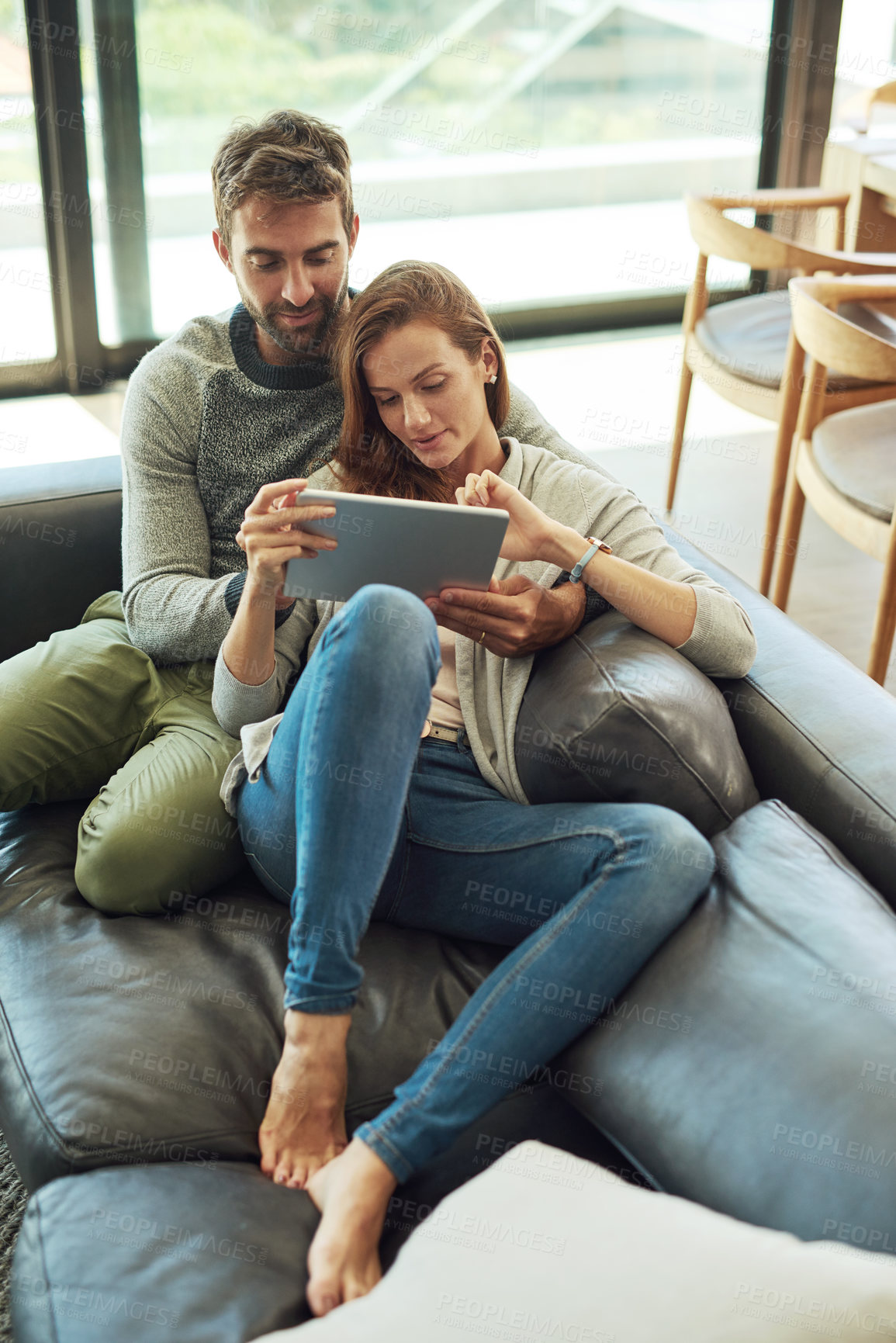 Buy stock photo Happy, couple and hug with tablet on sofa for streaming, movie subscription or tv selection at home. Smile, man and woman with tech and love embrace for bonding, show search and web entertainment