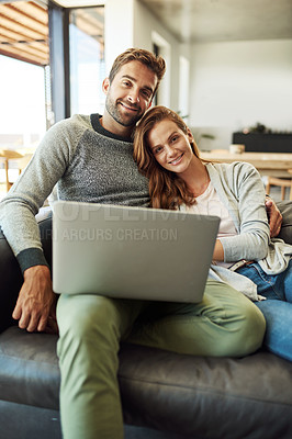 Buy stock photo Cropped portrait of an affectionate young couple using a laptop while relaxing on their sofa at home