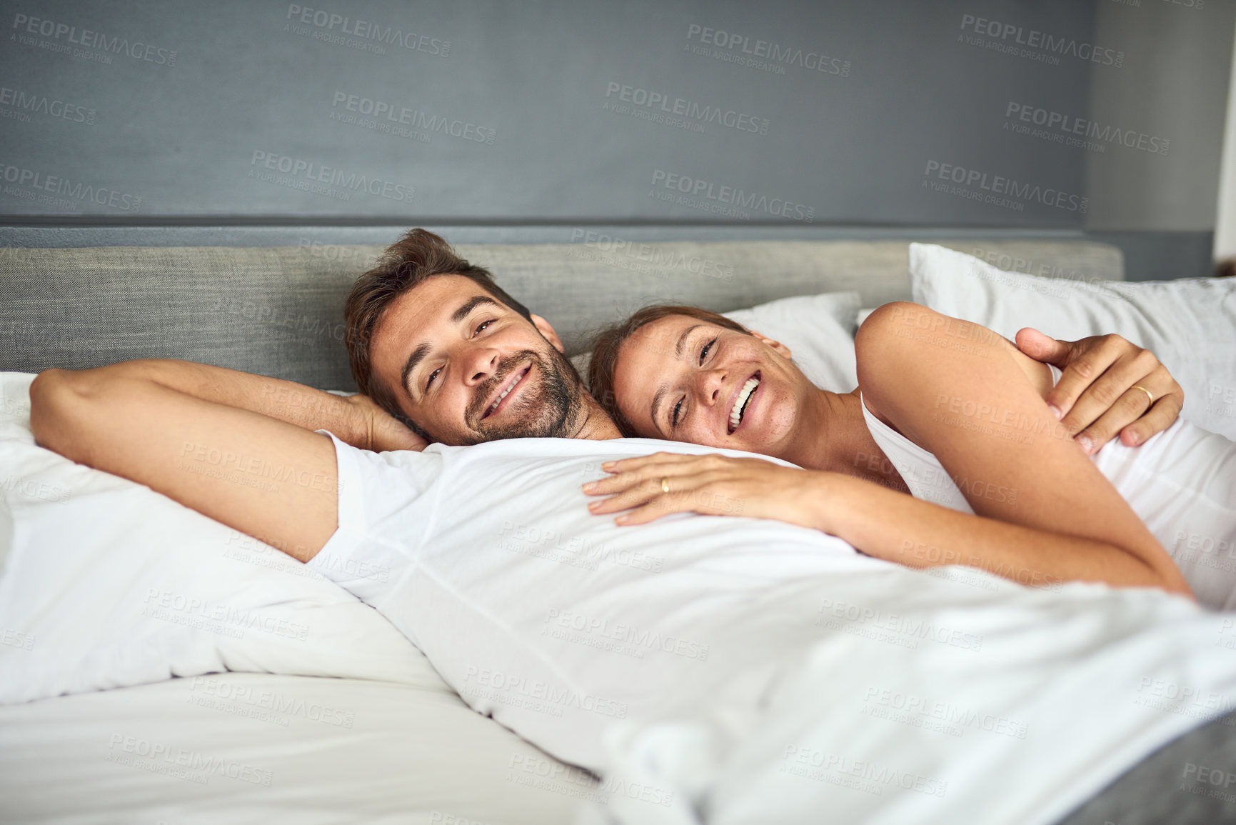 Buy stock photo Smile, couple and portrait relax on bed in morning, peace or support for marriage commitment at house. Love, woman and man with embrace care, relationship romance or wake up together on vacation
