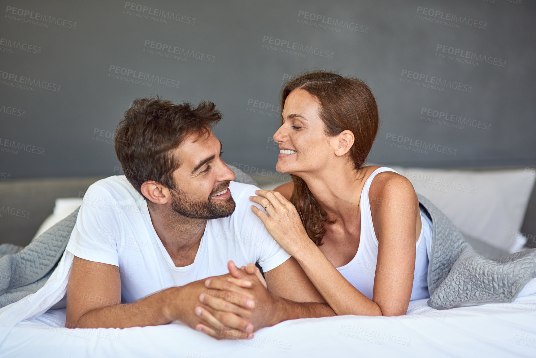 Buy stock photo Happy couple, relax or bonding on bed in morning, peace or love for marriage commitment at house. Wake up, loyalty or people with smile for romantic relationship, support and anniversary together