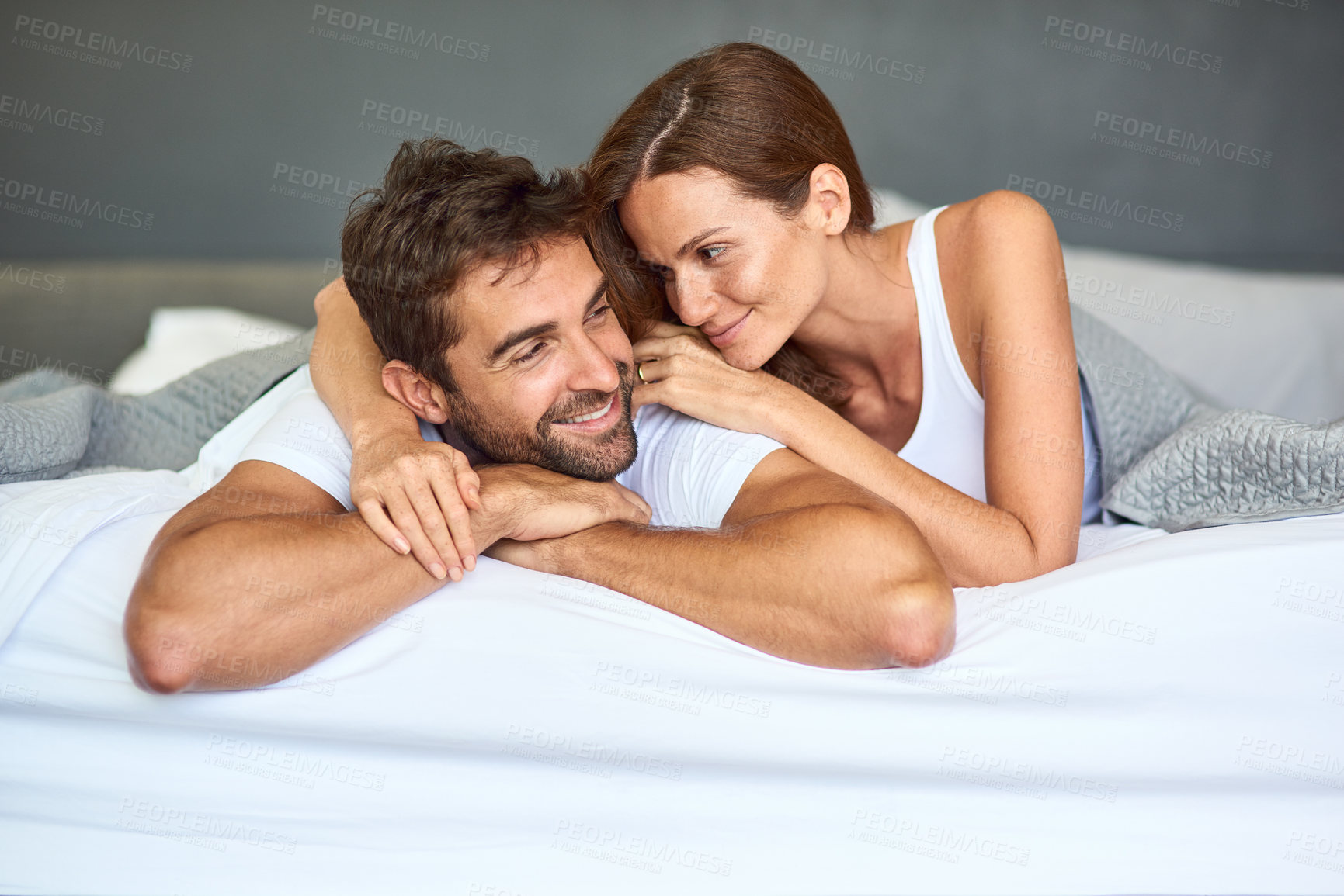 Buy stock photo Happy couple, wake up and resting in bedroom, morning or support for marriage commitment at house. Love, comfort or people bonding with smile for romantic relationship, peace or anniversary together