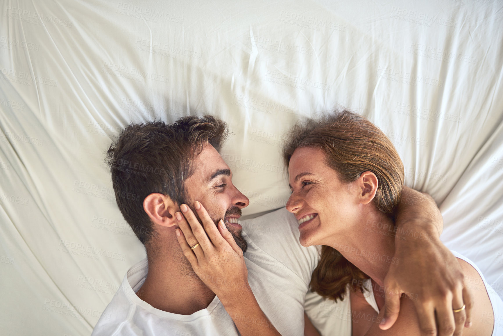 Buy stock photo Love, smile and couple relax on bed above view for bonding, peace or support of marriage commitment at house. Woman, man and hug of embrace care, relationship romance or wake up together for safety

