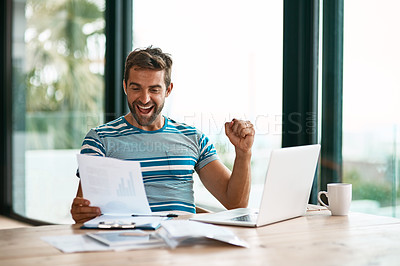 Buy stock photo Cropped shot of a handsome young male entrepreneur cheering while working from his home office