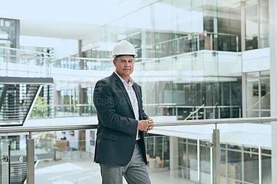 Buy stock photo Portrait of a confident professional male architect standing next to the development site while looking at the camera inside a building