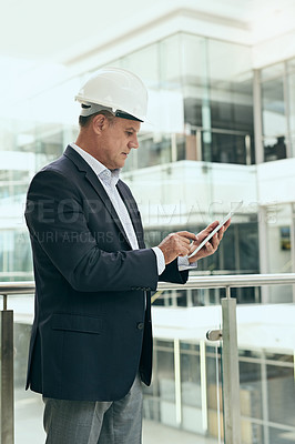 Buy stock photo Reading, tablet and mature man with helmet, construction and serious for update of plan for building. Balcony, architect and typing of businessman, online and thinking of architecture of property