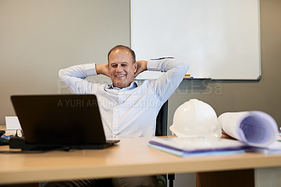 Buy stock photo Shot of a cheerful professional male businessman sitting back with his arms behind his head while looking at his laptop's screen