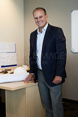 Buy stock photo Portrait of a cheerful professional businessman standing in the office while looking at the camera