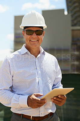 Buy stock photo Portrait of a professional male architect on a building site while working on a digital tablet and looking at the camera outside