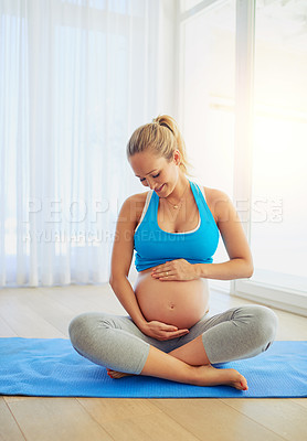 Buy stock photo Shot of a pregnant woman working out on an exercise mat at home