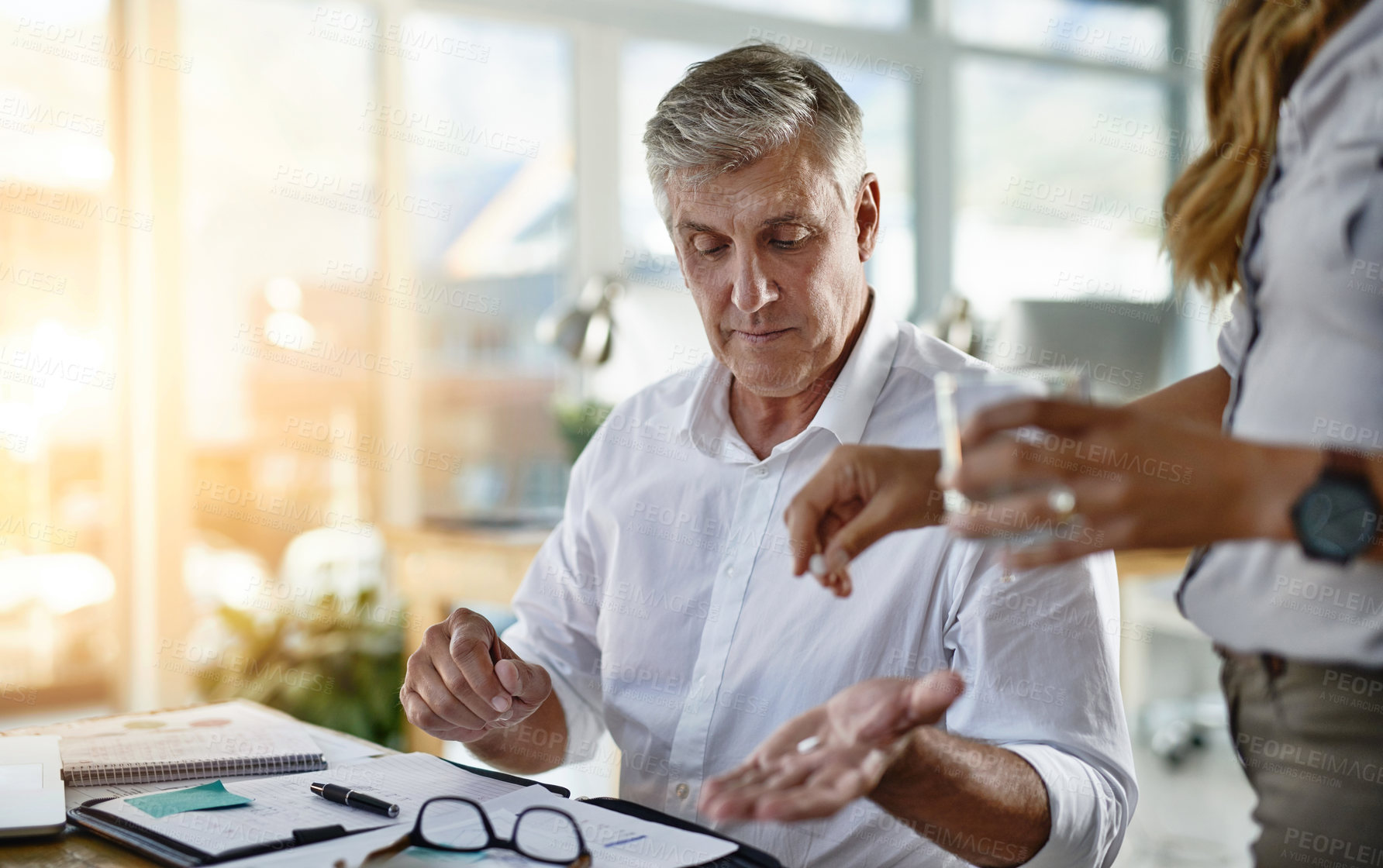 Buy stock photo Business, medicine and stress for mature man in office with help from assistant or employee. Glass, headache or pill and overworked corporate manager in workplace with symptoms of burnout migraine