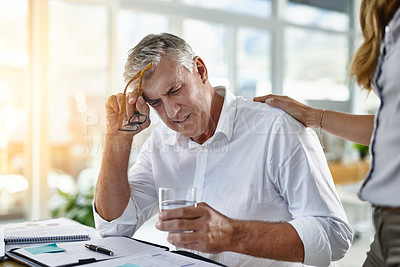 Buy stock photo Shot of a mature businessman suffering with a headache at work