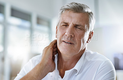 Buy stock photo Shot of a mature businessman experiencing body discomfort in the office