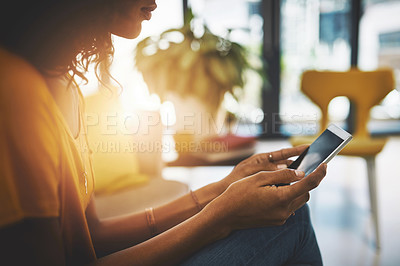 Buy stock photo Cropped shot of an unrecognizable young woman using her cellphone while relaxing at home on the weekend