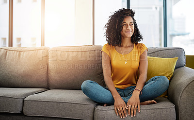 Buy stock photo Full length shot of an attractive young woman looking thoughtful while relaxing at home on the weekend