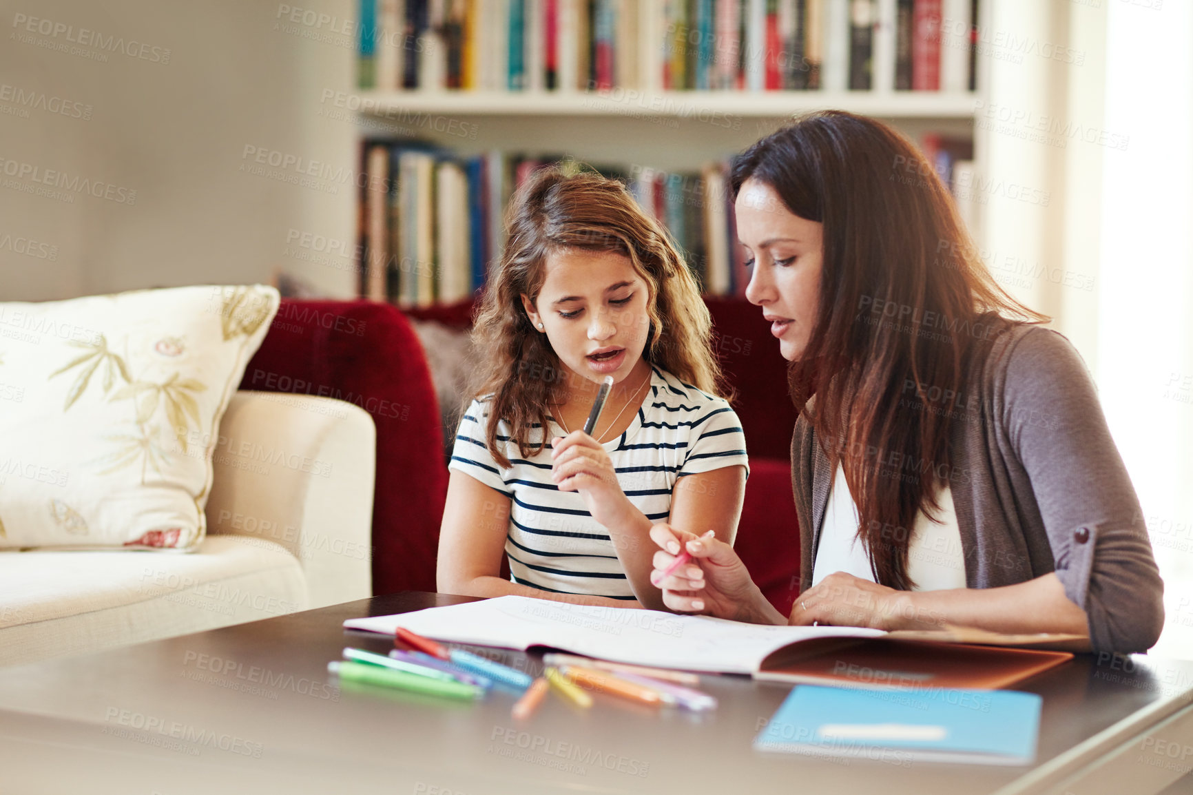 Buy stock photo Shot of a beautiful mother helping her adorable daughter with her homework at home