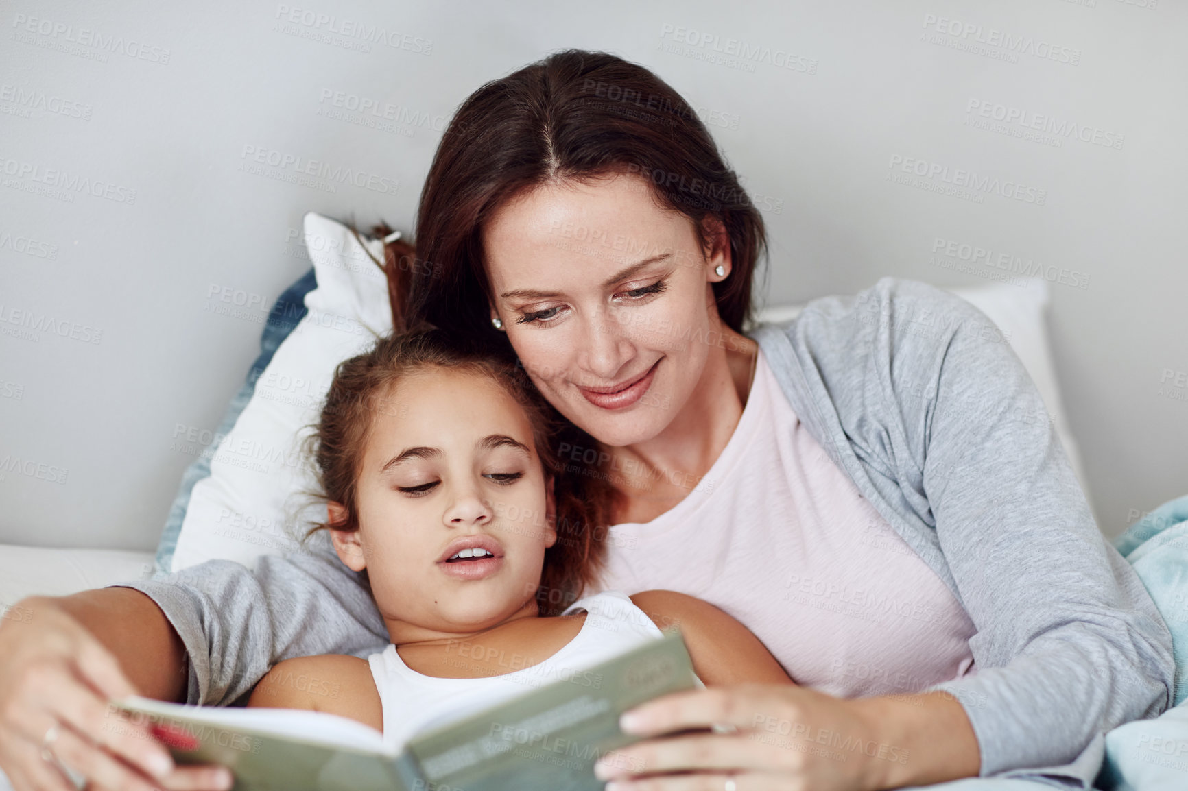 Buy stock photo Cropped shot of a mother and daughter reading a bedtime story together