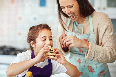 Buy stock photo Shot of a mother and daughter preparing food in the kitchen at home