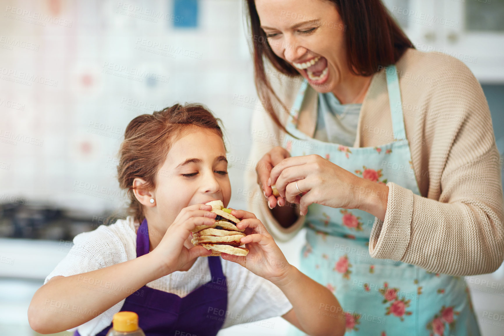 Buy stock photo Shot of a mother and daughter preparing food in the kitchen at home