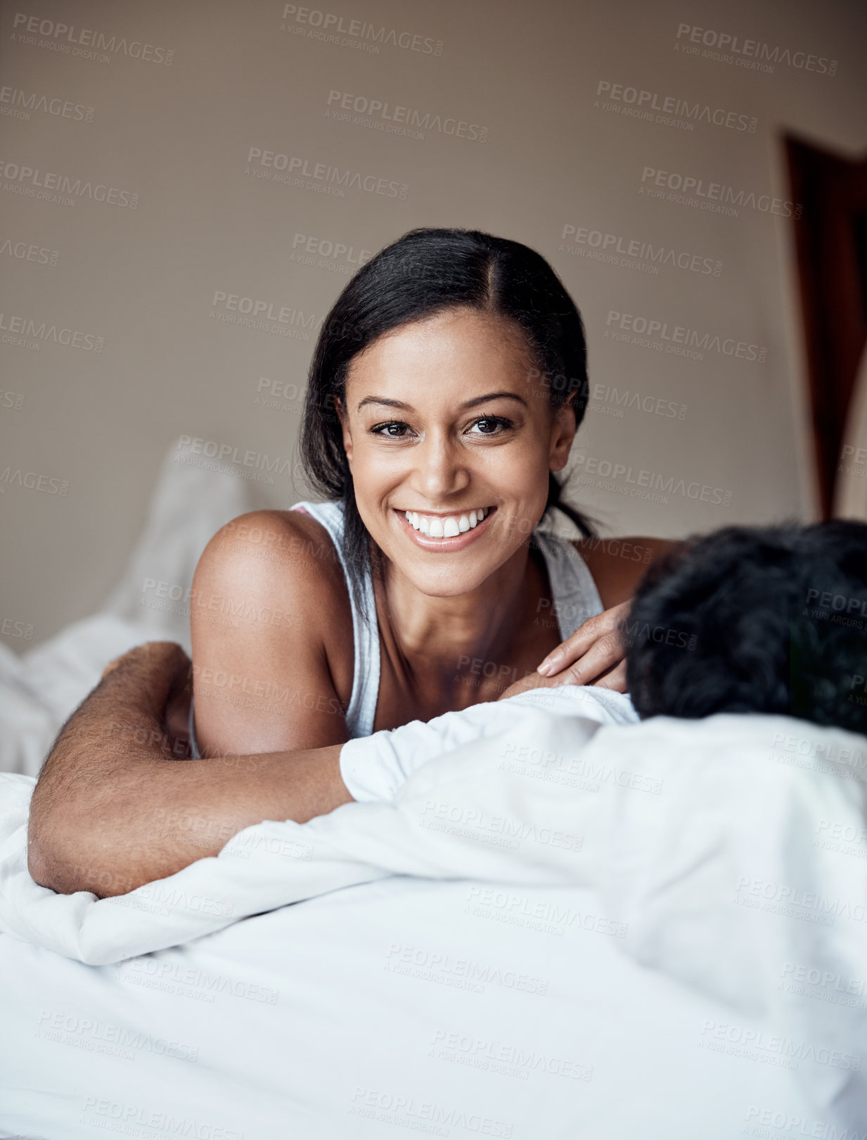 Buy stock photo Portrait of a young woman lying on a bed with her husband at home