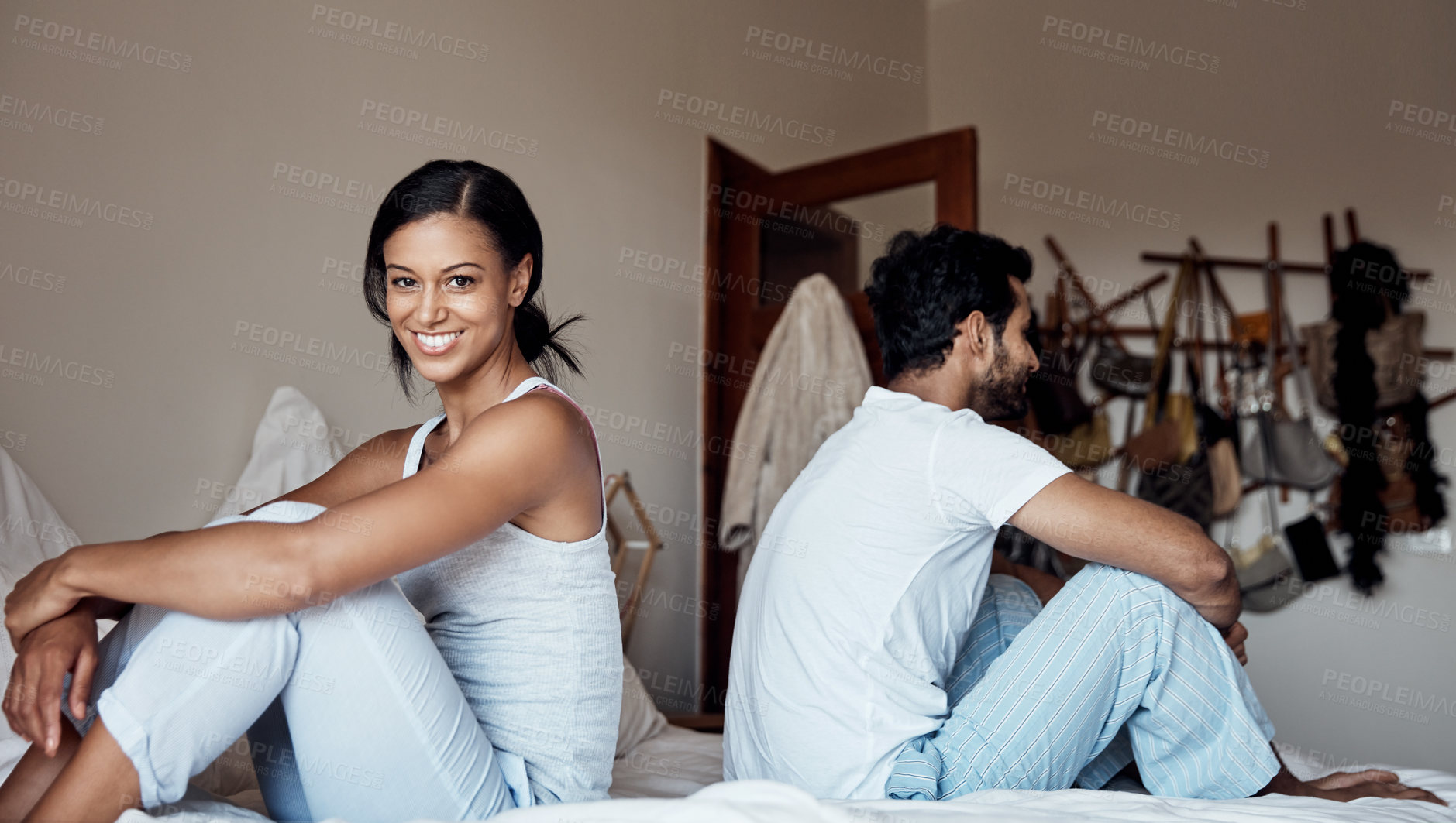 Buy stock photo Portrait of a young woman sitting on a bed with her husband at home