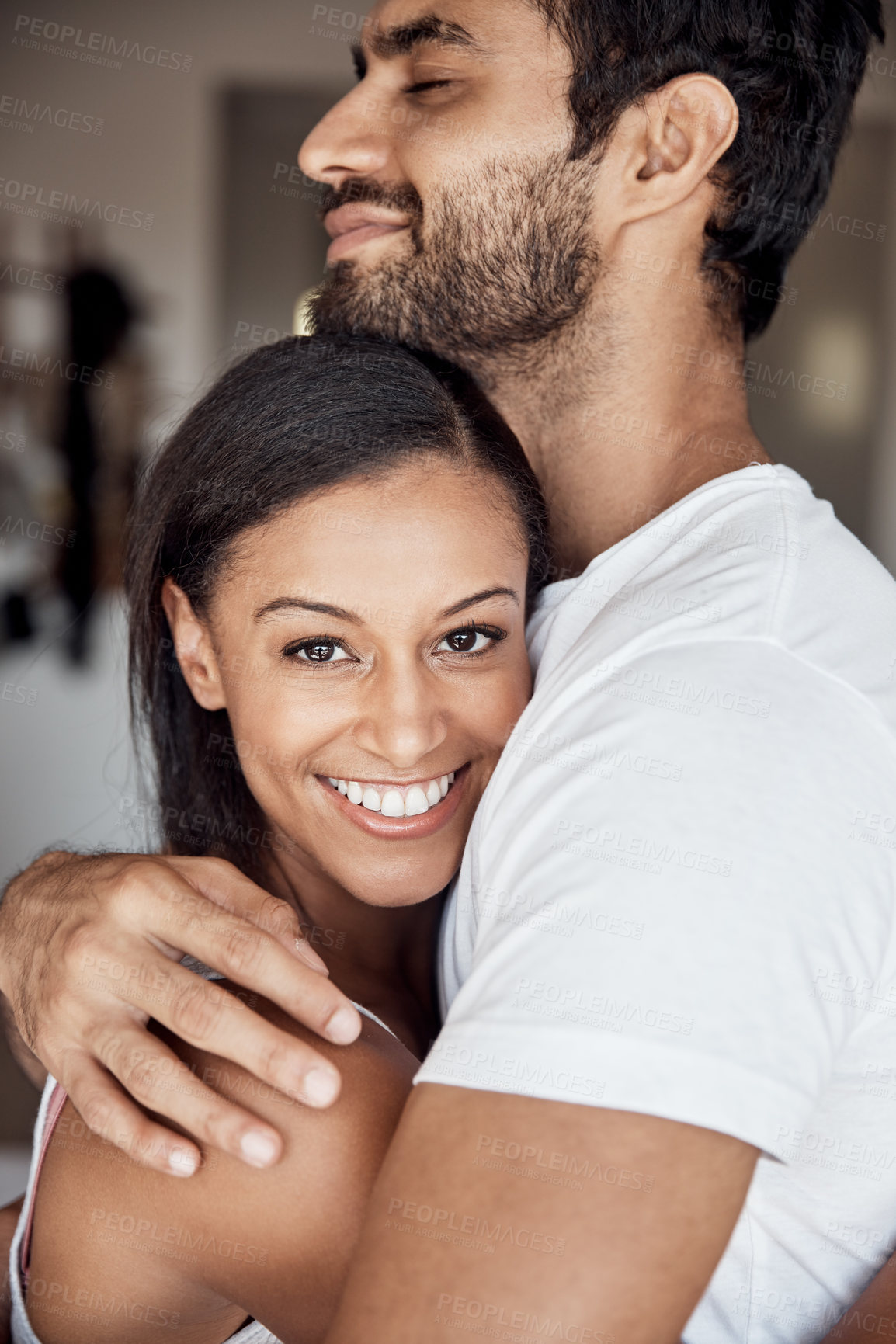 Buy stock photo Portrait of a young woman hugging her husband at home