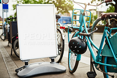 Buy stock photo Bike, mockup and sign at rental station for commute, tourism or safe public transportation in city. Bicycle, poster and space with retail service for holiday, travel or vacation in urban town