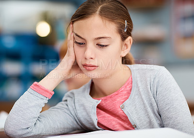 Buy stock photo Shot of a young elementary school girl looking bored while sitting in class