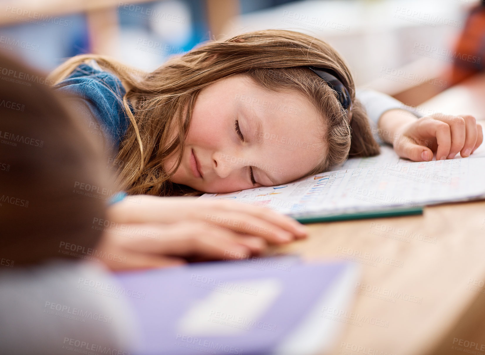 Buy stock photo Shot of an elementary school girl sleeping on her desk in class