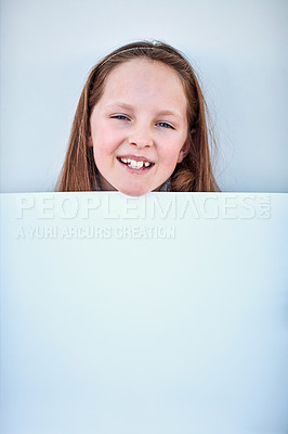 Buy stock photo Portrait of a little girl holding a blank board against a grey background