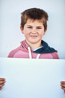 Buy stock photo Portrait of a little boy holding a blank board against a grey background