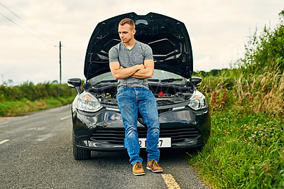 Buy stock photo Shot of a young man standing at his car after breaking down on the road