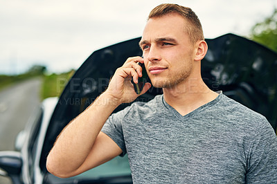 Buy stock photo Shot of a young man calling roadside assistance after breaking down