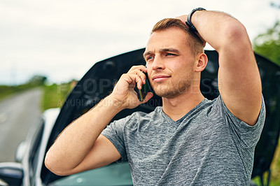 Buy stock photo Shot of a young man calling roadside assistance after breaking down