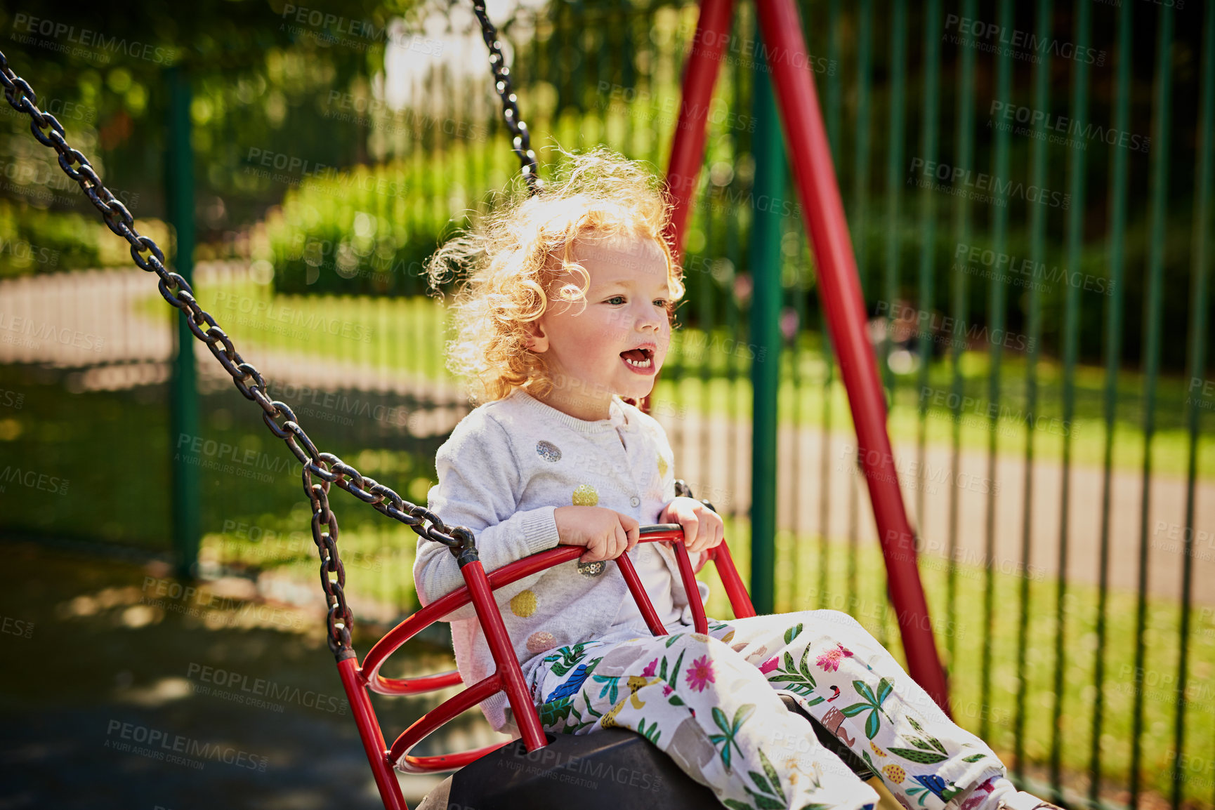 Buy stock photo Shot of an adorable little girl playing on the swing outdoors