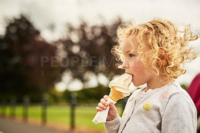 Buy stock photo Shot of an adorable little girl eating an ice cream cone outdoors