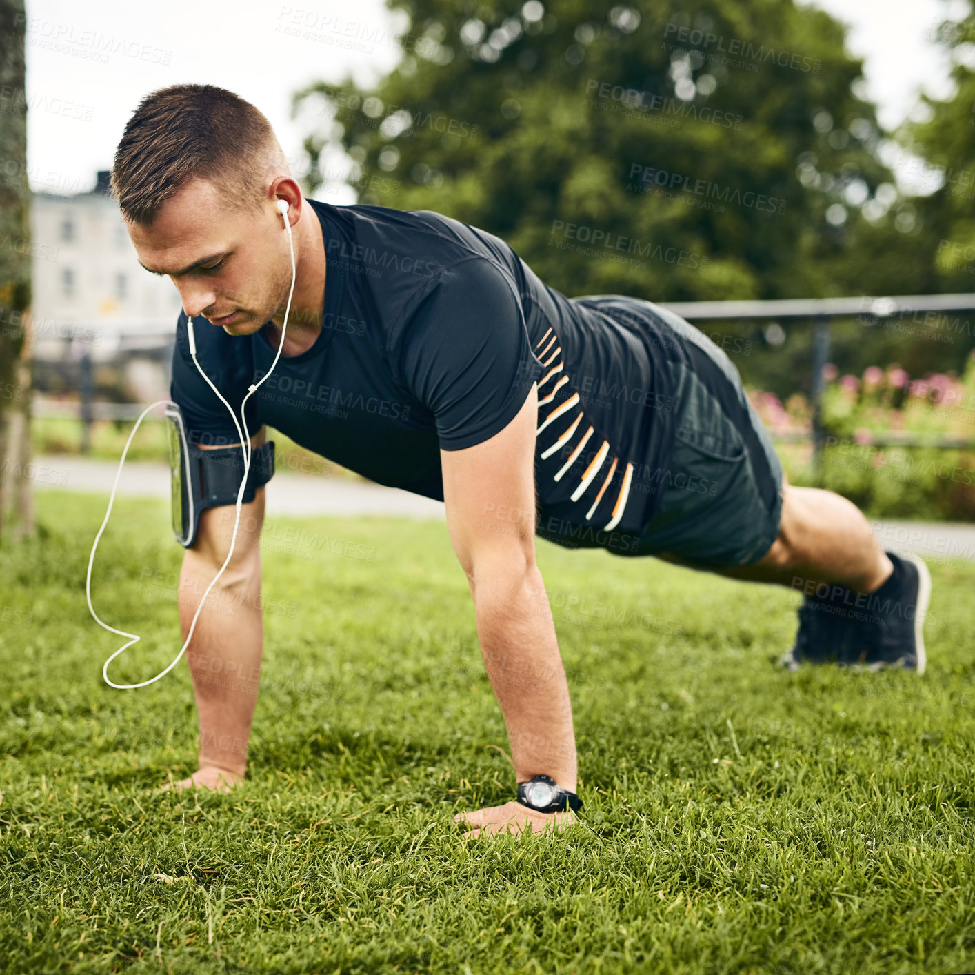 Buy stock photo Outdoor, balance and man with push ups for fitness, strength building and muscle growth with workout. Grass, bodybuilder and motivation with earphones for podcast, resilience or training for wellness