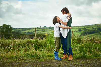 Buy stock photo Smile, mom and hug kids outdoor for love, care and bonding together with people on family holiday. Mama, happy children and embrace in countryside with baby for support, parenthood and mothers day