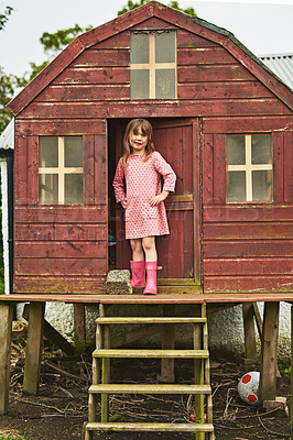 Buy stock photo Portrait, child and playful with tree house in backyard, family home or garden as little girl for fun in USA. Kid, adventure and happiness with confidence, smile or excited on weekend for development