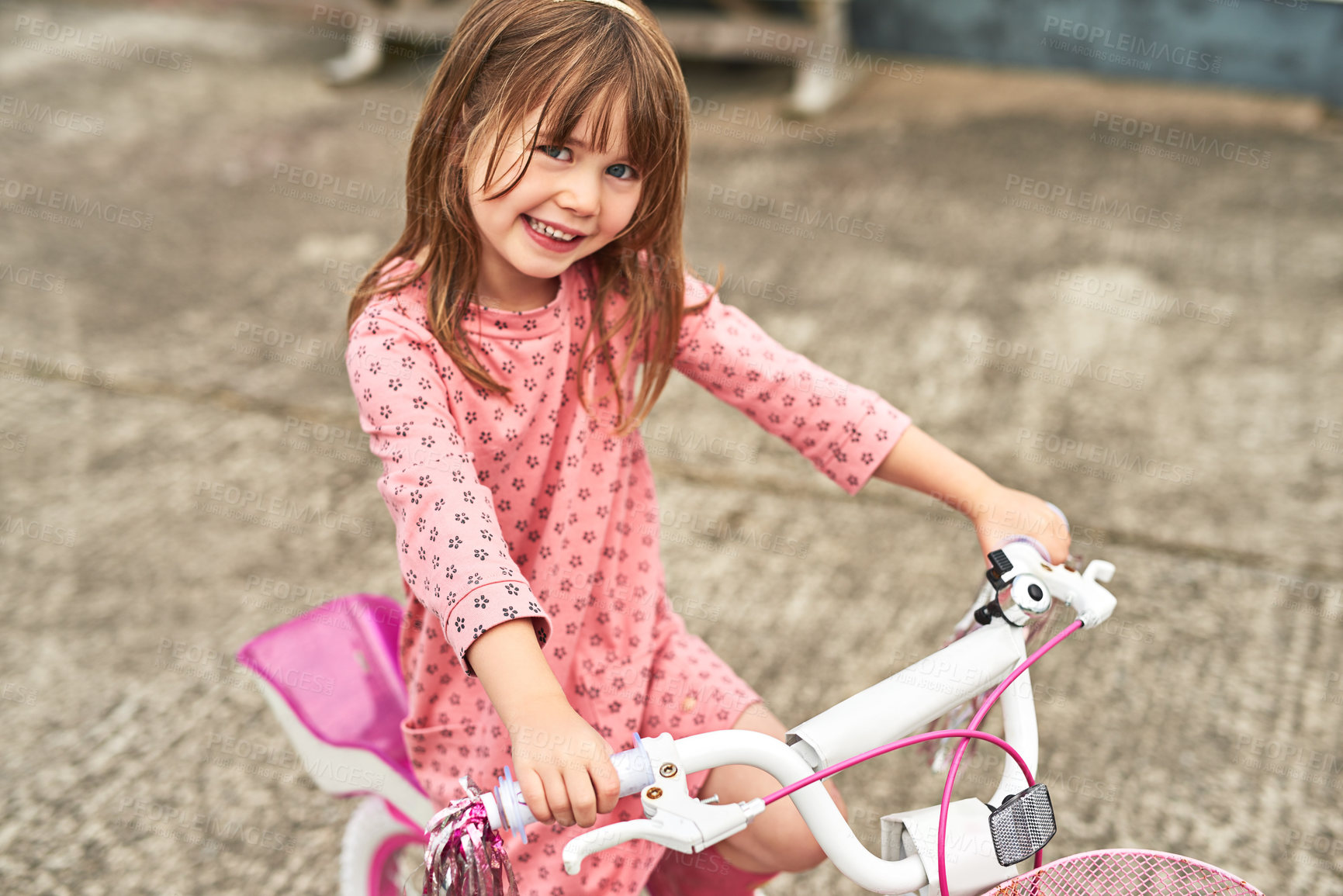 Buy stock photo Portrait of an adorable little girl riding her bike outdoors