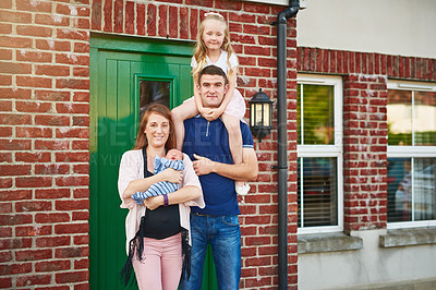 Buy stock photo Happy family, home and portrait at door for love, security and hug at brick wall. Parents, kids and piggyback at house for support, trust and pride for investment opportunity or real estate purchase