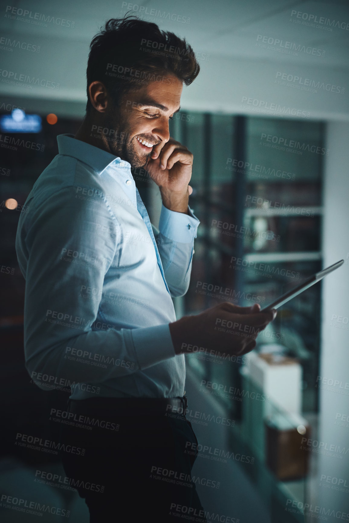 Buy stock photo Happy, businessman and night with tablet for social media, funny news or online research at office. Young man or employee laughing and working late on technology for humor or comedy at workplace