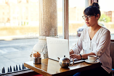 Buy stock photo Shot of a beautiful young woman using a laptop in a cafe