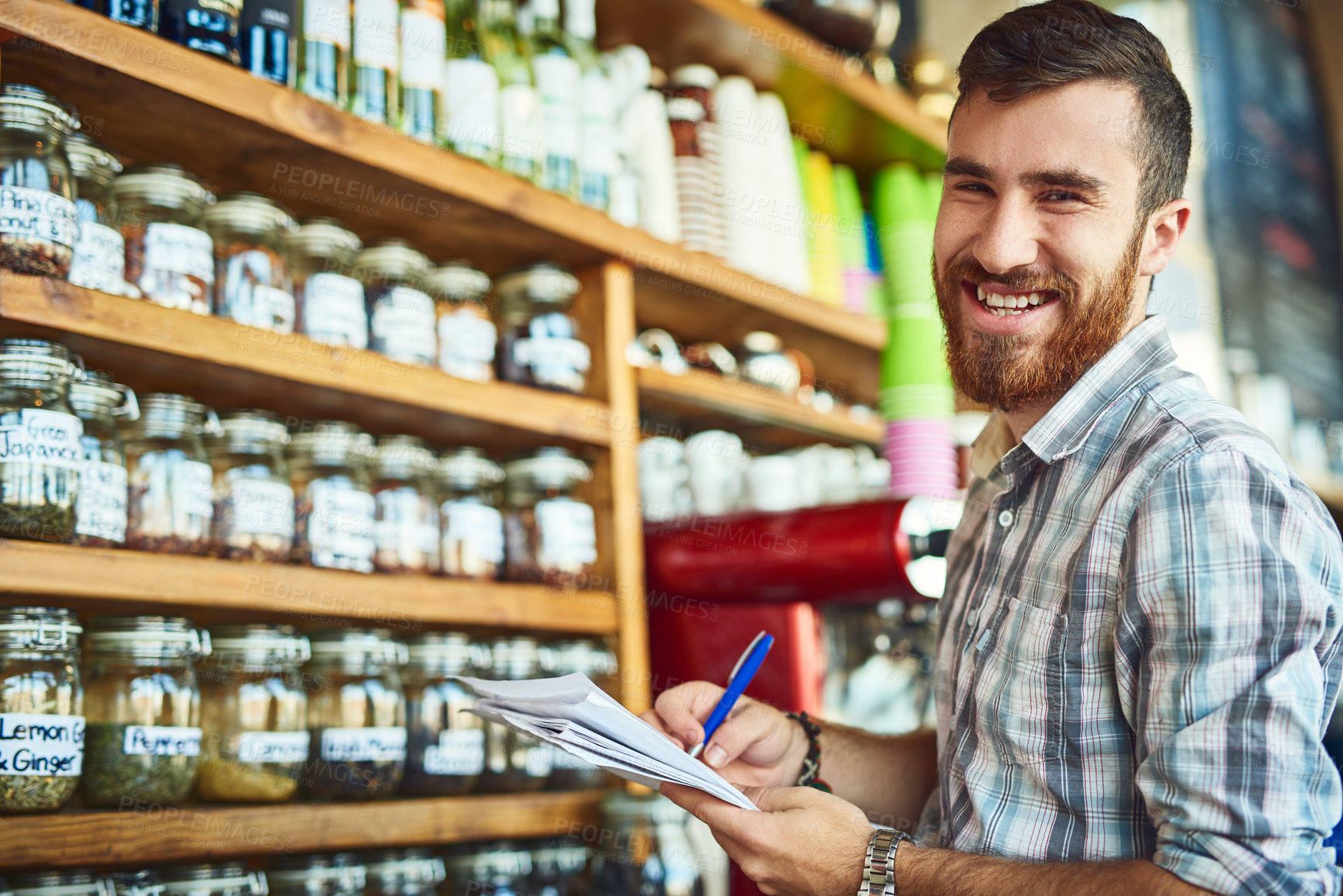 Buy stock photo Man, paperwork and shop owner in portrait at cafe by shelf, writing and inspection for stock with smile. Person, entrepreneur and documents with notes, inventory and restaurant management in Turkey