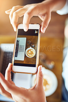 Buy stock photo Shot of an unrecognizable woman taking a picture of her coffee with a cellphone in a cafe